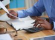Gentleman of African descent looking at a document while on his calculator | KRA Pin registration services in Kenya | Business registration services in Nairobi